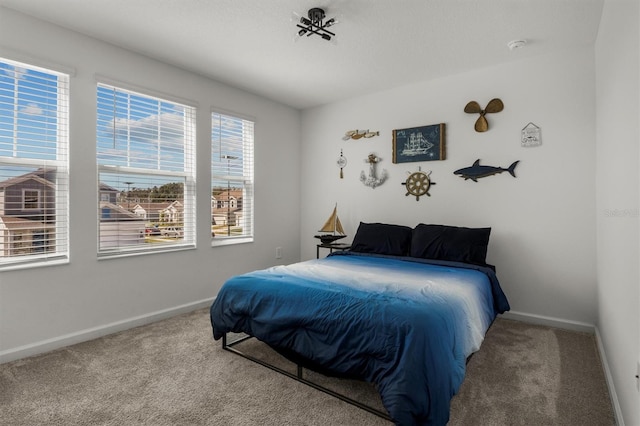 carpeted bedroom featuring baseboards