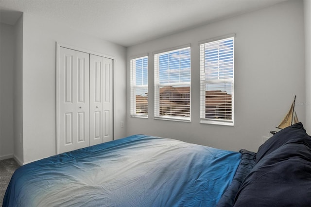 bedroom featuring a closet, baseboards, and carpet floors