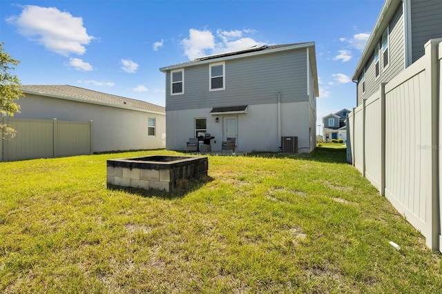 back of property with a yard, central AC, and fence