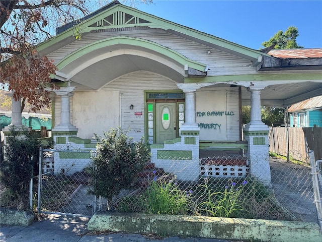 view of front of home featuring a fenced front yard, a porch, and a gate