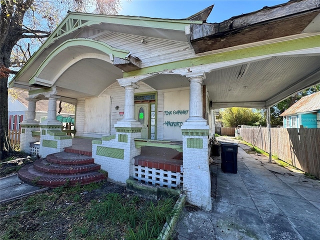 view of front of property featuring an attached carport and fence