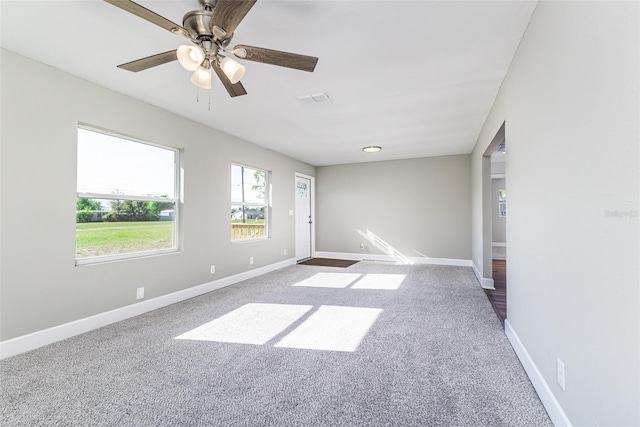 spare room with visible vents, carpet floors, baseboards, and a ceiling fan