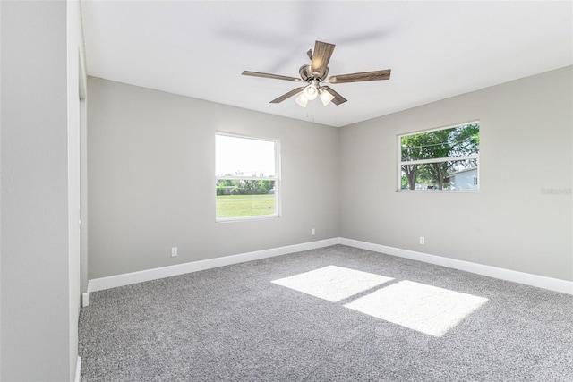 unfurnished room featuring a healthy amount of sunlight, baseboards, and ceiling fan