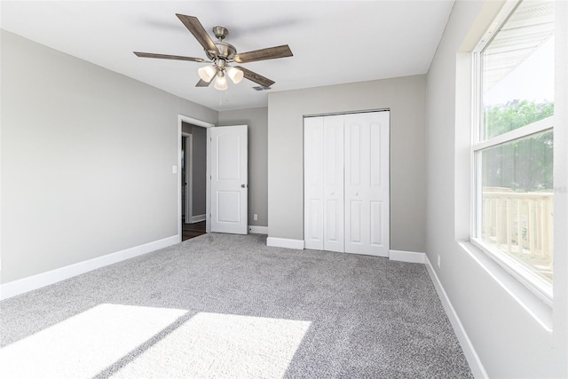 unfurnished bedroom with visible vents, a closet, carpet, baseboards, and ceiling fan