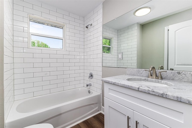 full bath featuring vanity, shower / tub combination, wood finished floors, and a wealth of natural light