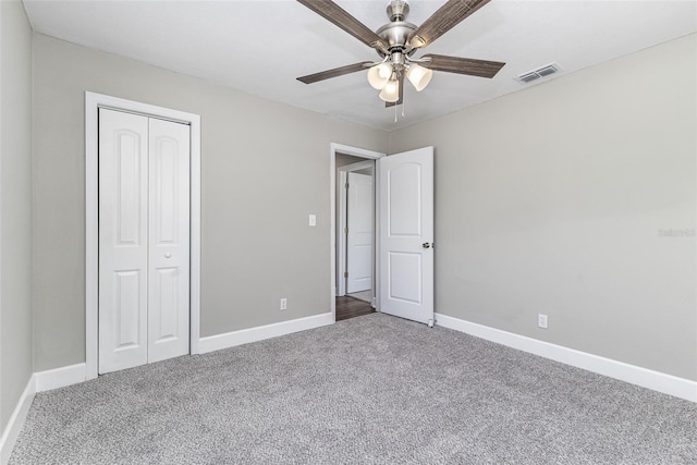 unfurnished bedroom featuring a ceiling fan, visible vents, baseboards, a closet, and carpet flooring