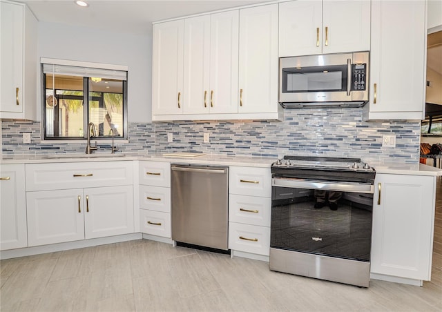 kitchen featuring light countertops, white cabinets, appliances with stainless steel finishes, and a sink