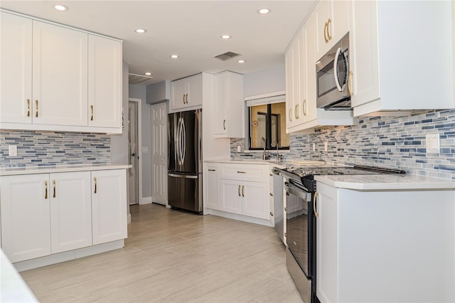 kitchen with appliances with stainless steel finishes, white cabinets, and light countertops