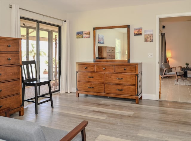 sitting room with baseboards and light wood-style floors