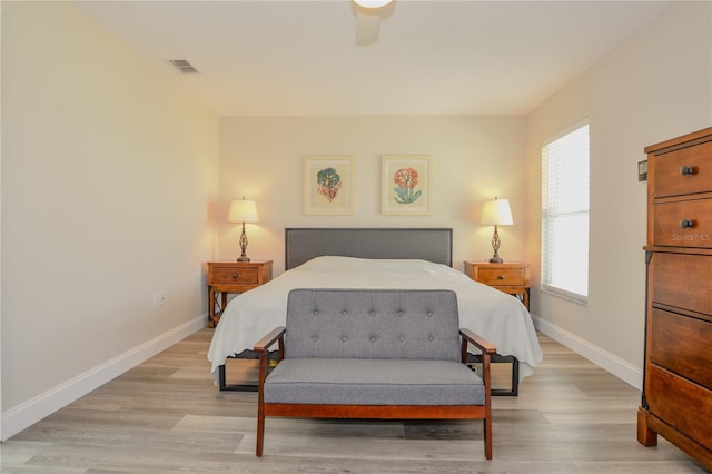 bedroom featuring light wood-type flooring, visible vents, and baseboards