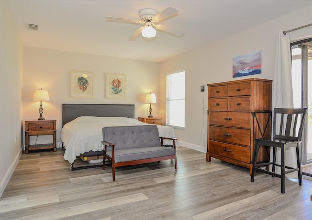 bedroom with visible vents, baseboards, and light wood finished floors