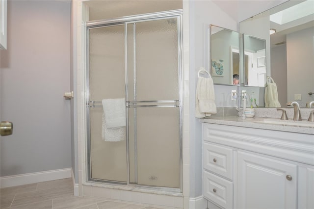 bathroom featuring a shower stall, vanity, and baseboards