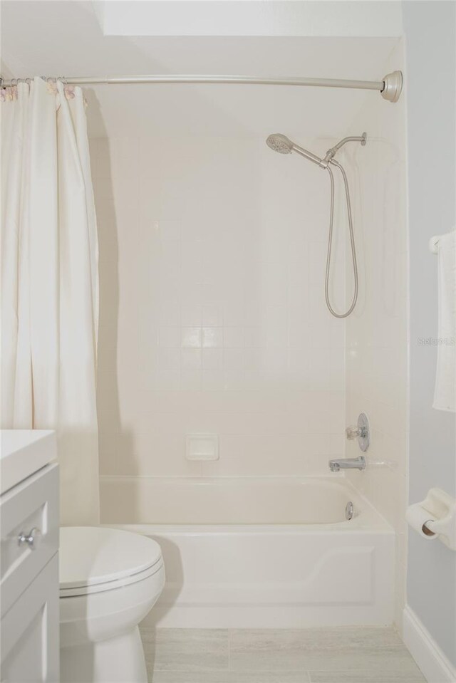 bathroom featuring vanity, shower / bath combination with curtain, and toilet