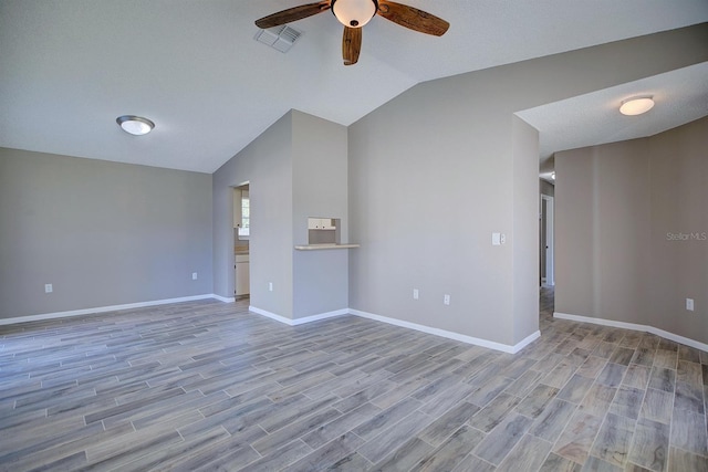 unfurnished living room with baseboards, lofted ceiling, ceiling fan, and wood finished floors