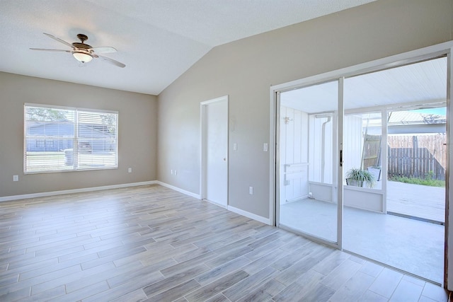 unfurnished room with plenty of natural light, lofted ceiling, ceiling fan, and light wood finished floors