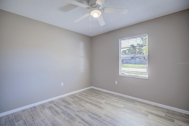 spare room with baseboards, a textured ceiling, and ceiling fan