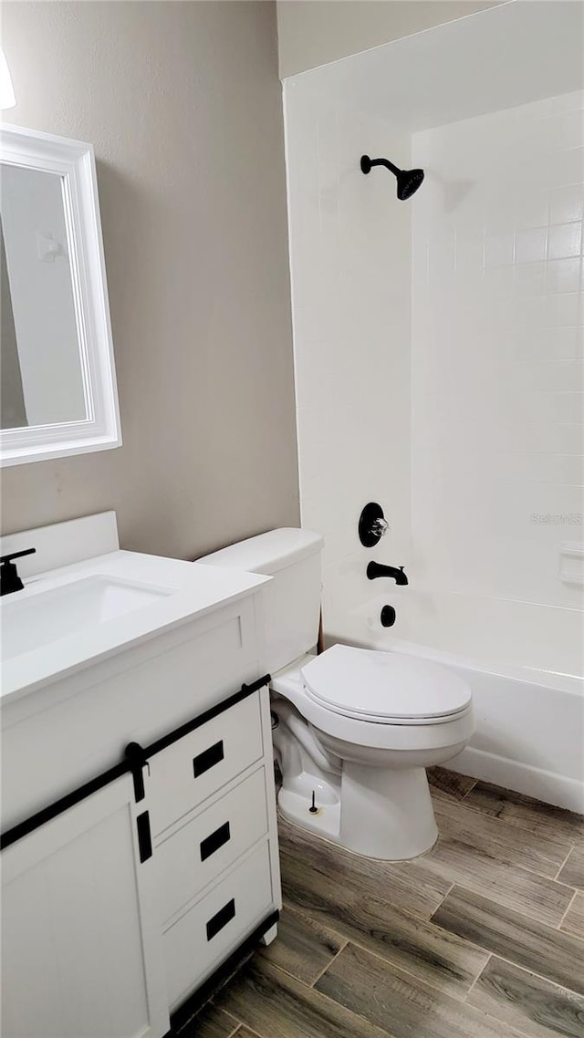 bathroom featuring vanity, bathing tub / shower combination, toilet, and wood finished floors