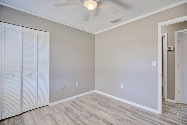 unfurnished bedroom featuring visible vents, a closet, ornamental molding, and light wood finished floors