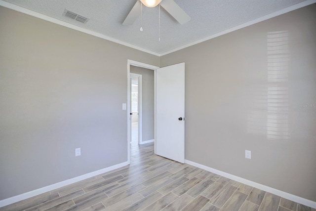 unfurnished room featuring visible vents, crown molding, wood finish floors, a textured ceiling, and a ceiling fan