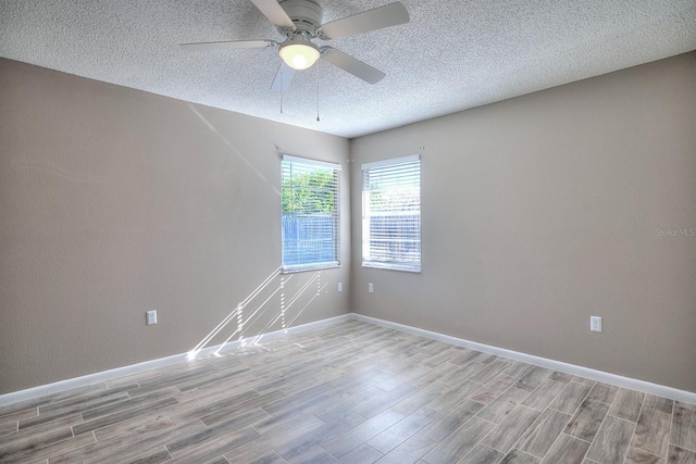 empty room with baseboards, a ceiling fan, and light wood finished floors