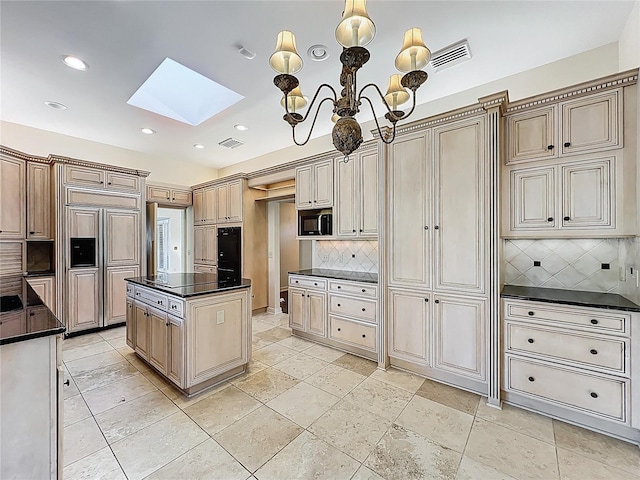 kitchen featuring visible vents, dark countertops, black appliances, and a skylight