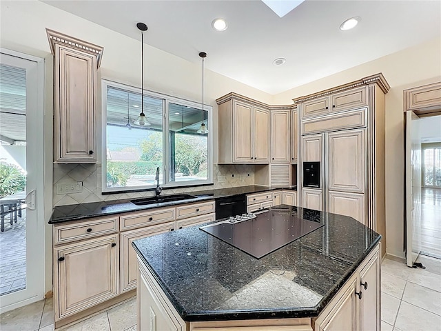 kitchen featuring tasteful backsplash, a kitchen island, black appliances, and a sink