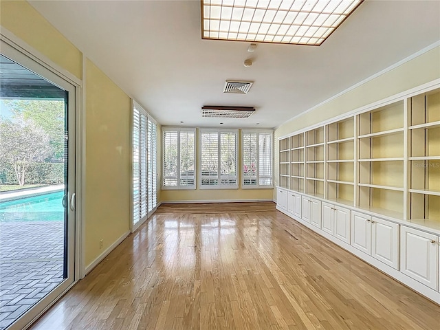 unfurnished room with visible vents, a healthy amount of sunlight, and light wood-style flooring