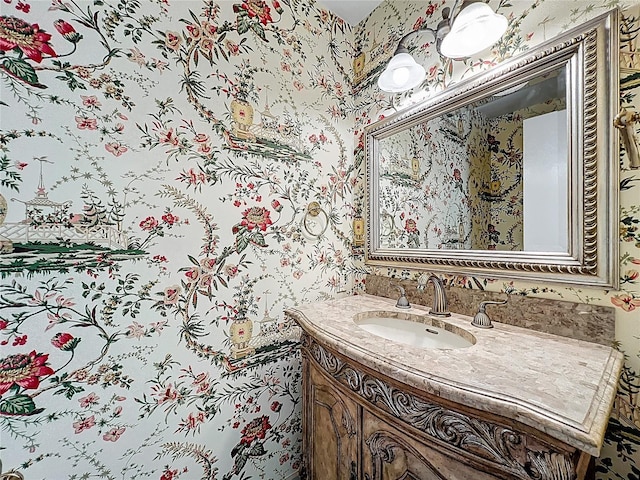 bathroom featuring vanity and wallpapered walls