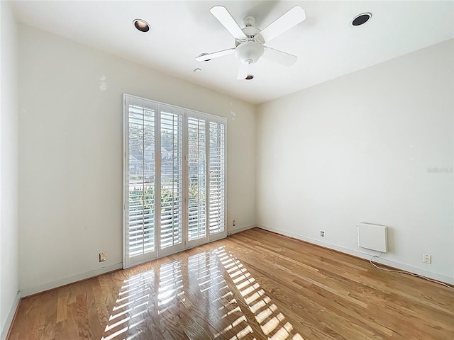 spare room with a ceiling fan, wood finished floors, and baseboards