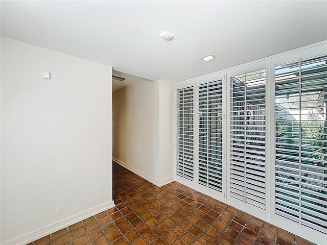 spare room featuring recessed lighting, visible vents, and baseboards