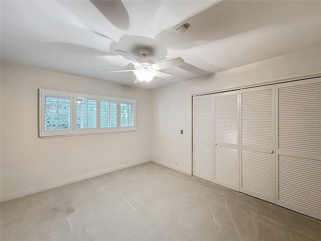 unfurnished bedroom featuring a closet, baseboards, concrete floors, and a ceiling fan