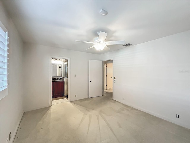 unfurnished bedroom with ceiling fan, visible vents, and ensuite bath