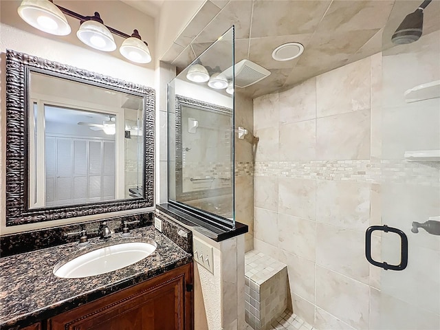 bathroom with a tile shower and vanity