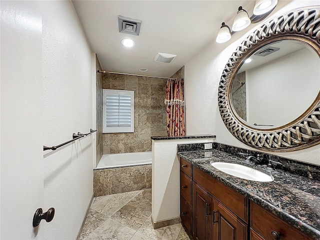 bathroom featuring vanity, tiled shower / bath, and visible vents