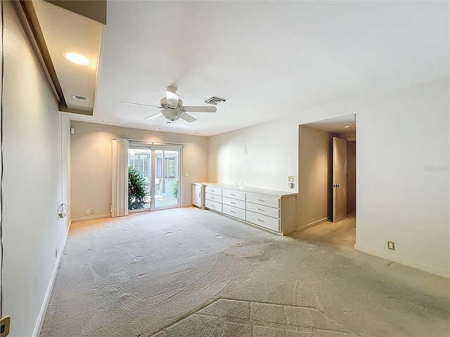 spare room featuring visible vents, light colored carpet, baseboards, and ceiling fan