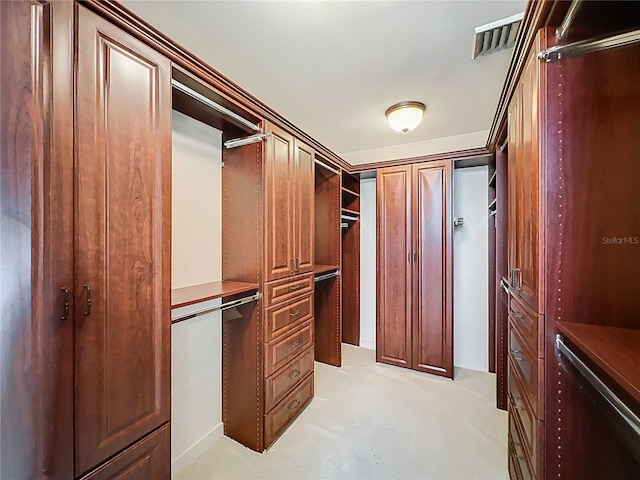 spacious closet with light colored carpet and visible vents