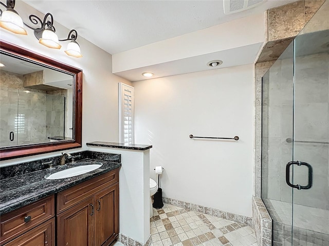 bathroom featuring visible vents, toilet, a stall shower, and vanity