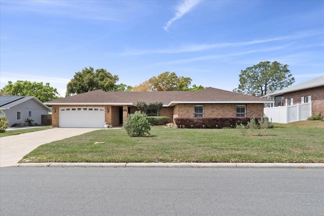 ranch-style home featuring fence, concrete driveway, a front yard, a garage, and brick siding