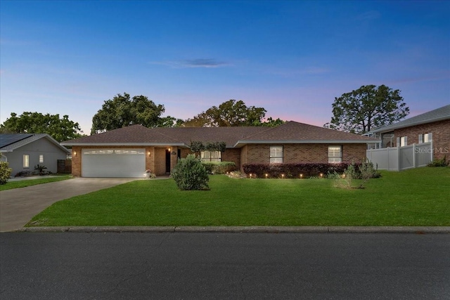 single story home featuring an attached garage, driveway, a yard, and fence