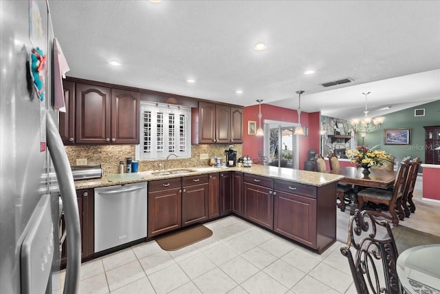 kitchen featuring visible vents, a sink, tasteful backsplash, appliances with stainless steel finishes, and light stone countertops