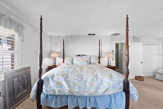 carpeted bedroom with visible vents and a textured ceiling
