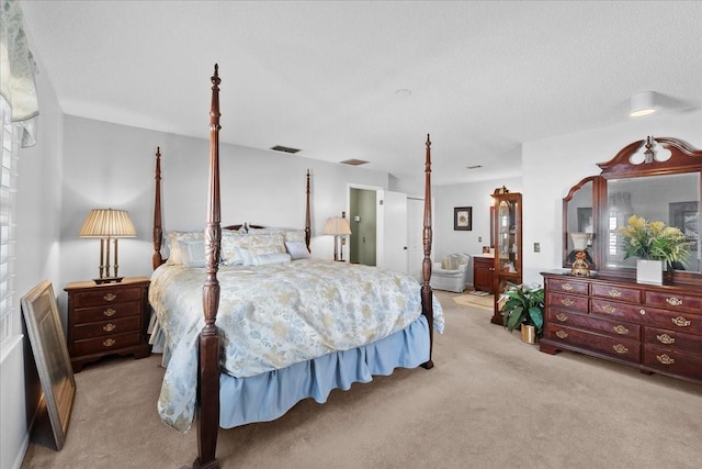 carpeted bedroom featuring visible vents, a textured ceiling, and ensuite bathroom