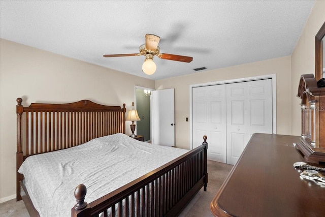 bedroom with visible vents, light colored carpet, a closet, and ceiling fan
