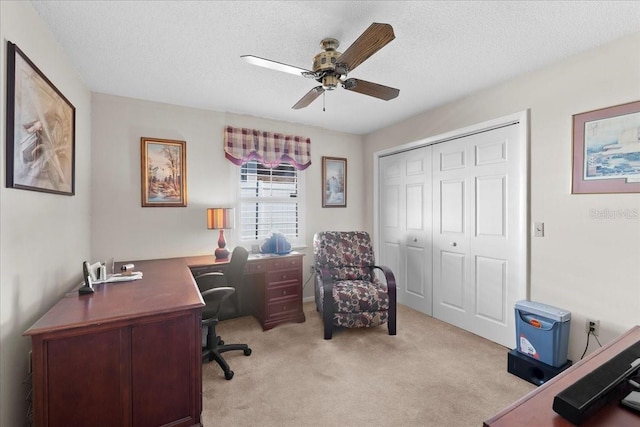 carpeted office space featuring a textured ceiling and ceiling fan