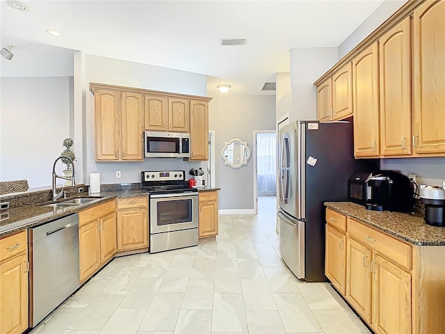 2420 Windchaser Ct, Melbourne, FL 32904 - kitchen featuring dark stone countertops, a sink, light brown cabinetry, and appliances with stainless steel finishes