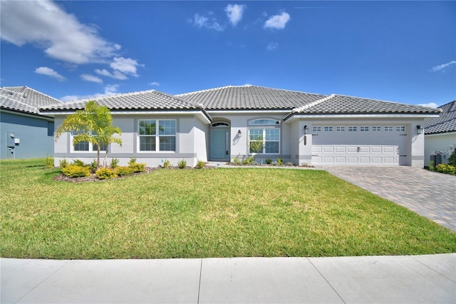 view of front of house with stucco siding, an attached garage, a tiled roof, decorative driveway, and a front yard