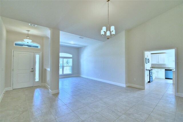 entrance foyer featuring visible vents, baseboards, a towering ceiling, an inviting chandelier, and light tile patterned floors
