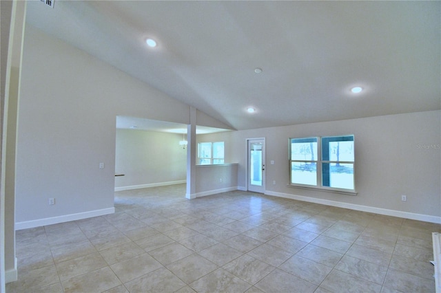 unfurnished room featuring plenty of natural light, baseboards, and lofted ceiling