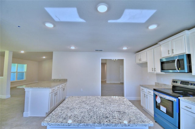 kitchen with appliances with stainless steel finishes, light stone counters, and visible vents
