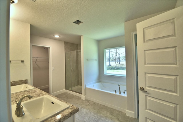 full bath featuring a bath, a sink, a spacious closet, and a shower stall